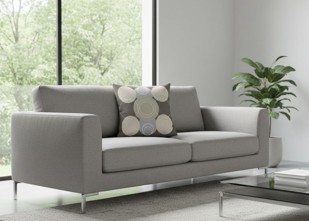 Grey sofa with a decorative cushion in a modern living room.