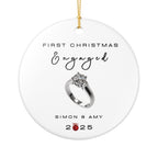 Round ceramic Christmas ornament featuring an engagement ring and the text "First Christmas Engaged" followed by personalised names and the year. White background.