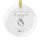 Round glass Christmas ornament featuring an engagement ring and the text "First Christmas Engaged" followed by personalised names and the year. 