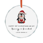 A round cyrstal glass Christmas ornament featuring an illustrated penguin wearing a Santa hat. It displays custom text that begins, "Happy 1st Christmas as My," followed by a personalised grandparent title, name and custom message.