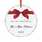 Round crystal glass Christmas ornament featuring a red bow and the text "Our First Christmas As Mr & Mrs" followed by a personalised surname and the year.