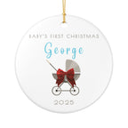 Round ceramic Christmas ornament featuring a baby carriage (pram) design accented with a red bow. Personalised text includes the baby's name, the year, and the phrase "Baby's First Christmas".  White background.