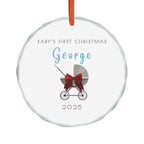 Round crystal glass Christmas ornament featuring a baby carriage (pram) design accented with a red bow. Personalised text includes the baby's name, the year, and the phrase "Baby's First Christmas".  