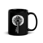 Black glossy ceramic mug with a delicate white dandelion design and a custom name printed on the front. 11oz personalised coffee cup, ideal for tea, coffee, or hot chocolate lovers.