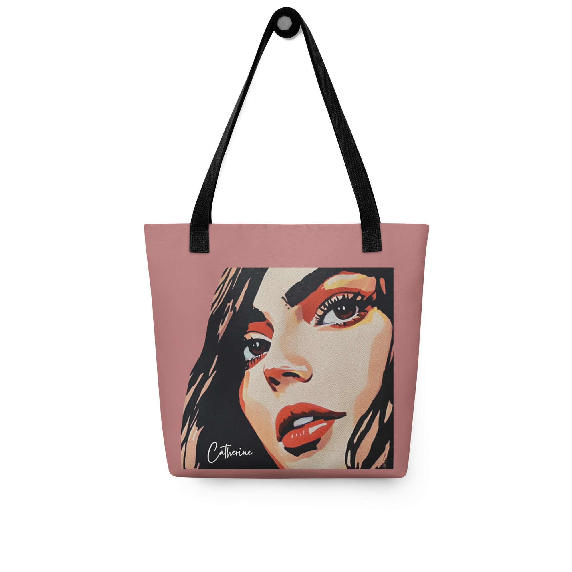 A pink tote bag with an  illustration of a woman's face. Below the face is a visible space for custom text, for "Your Name." The bag has two  black handles for carrying.