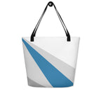 Back view of a large tote bag with black handles and a blue, grey, and white geometric pattern.