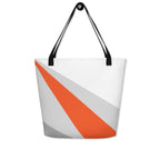Back view of a large tote bag with black handles and an orange, grey, and white geometric pattern.