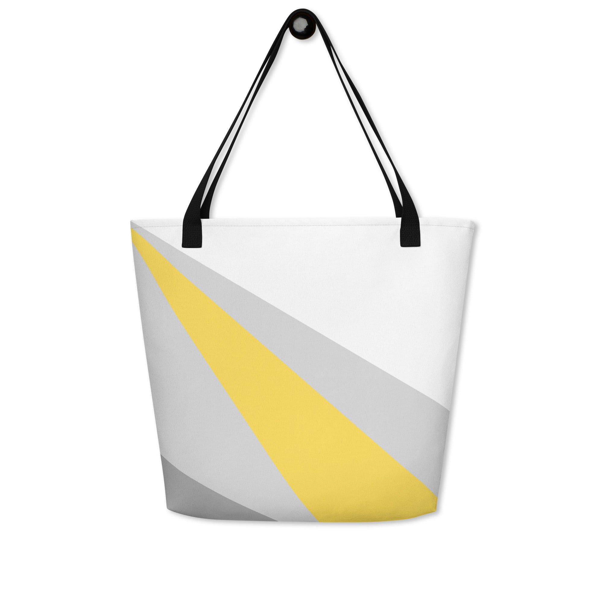 Back view of a large tote bag with black handles and a yellow, grey, and white geometric pattern.