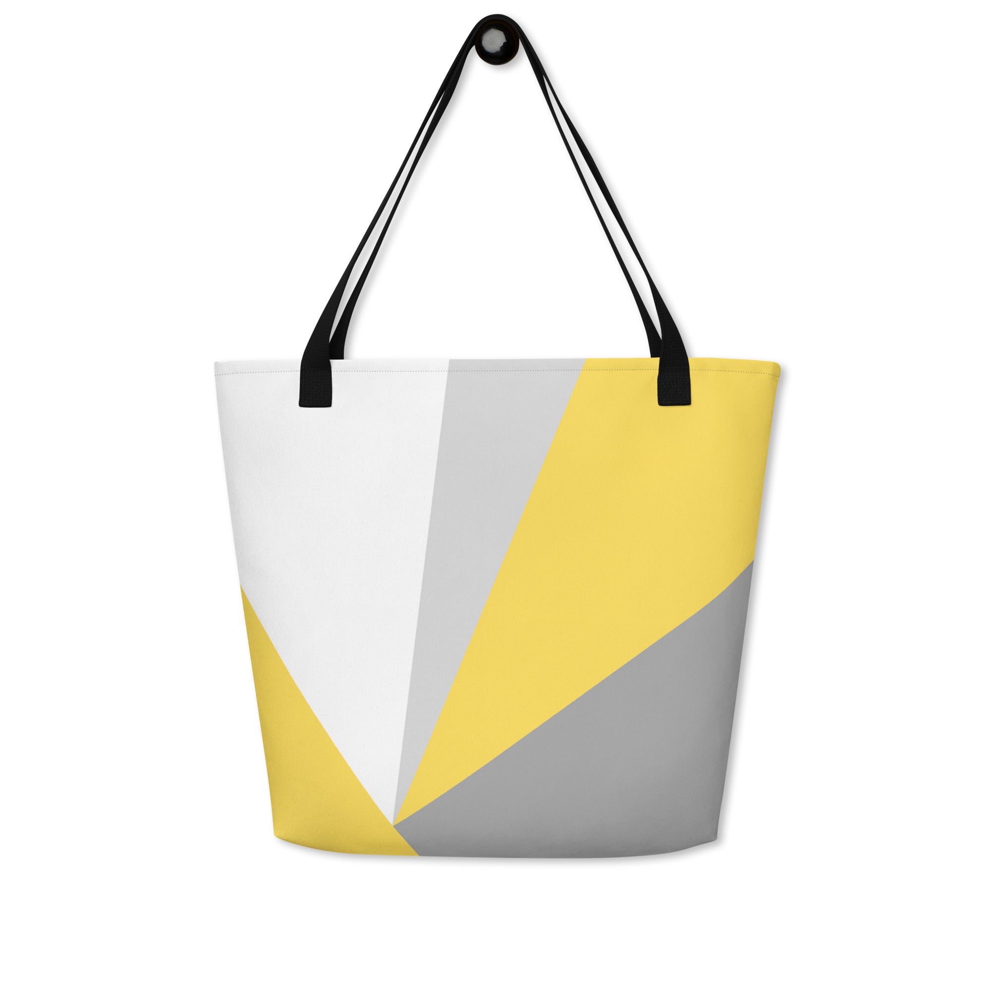 Front view of a large tote bag with black handles and a yellow, grey, and white geometric pattern.