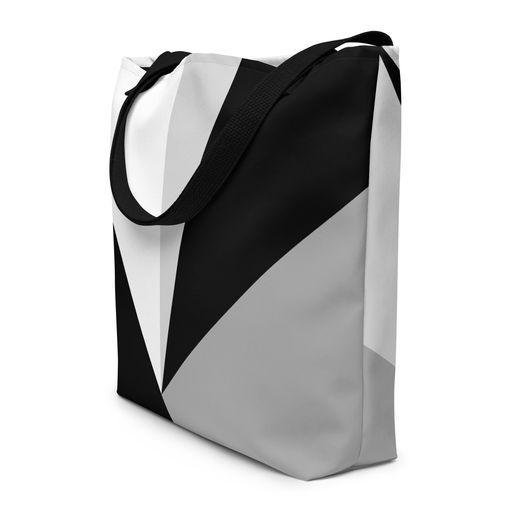 Side view of a large tote bag with black handles and a black, grey, and white geometric pattern.