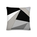 Front view of a cushion with geometric pattern made of triangles in shades of black, grey, sand and white.