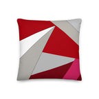 Front view of a cushion with geometric pattern made of triangles in shades of red, grey, sand and white.