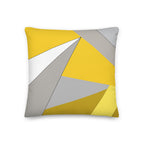 Front view of a cushion with geometric pattern made of triangles in shades of yellow, grey, sand and white.