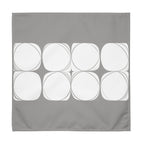 Grey cloth napkin featuring an abstract pattern of eight white circles arranged in two rows.