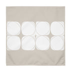 Sand coloured cloth napkin featuring an abstract pattern of eight white circles arranged in two rows.