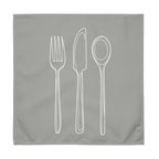 Grey cloth napkin with a detailed white drawing of a fork, knife, and spoon stacked vertically down the center.