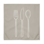 Sand colour cloth napkin with a detailed white drawing of a fork, knife, and spoon stacked vertically down the center.