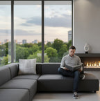 Grey and white linear cushion on grey sofa, city view in background.